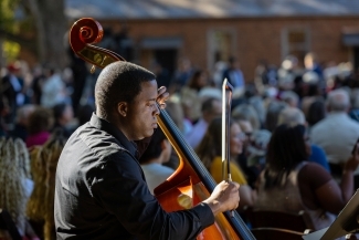 African American musician playing cello at the With These Hands dedication ceremony