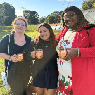 Students smiling with mocktails at A Farmers Dinner