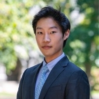College age man with dark hair, medium skin tone and a blue suit