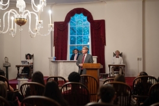 a college president speaks in a historic room with students