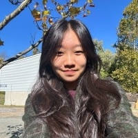 Bryn Mawr College student with long dark hair takes a selfie outdoors