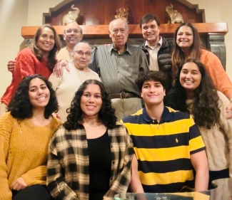 a family standing and sitting together