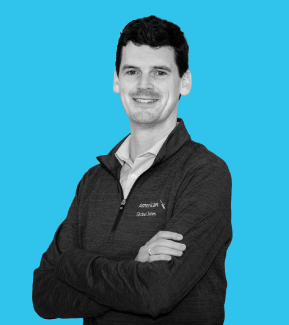 Young white man with arms crossed and dark hair