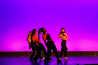 a group of young women dance on stage