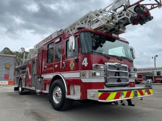 A red Columbia Fire Department ladder truck, numbered 4, parked on an asphalt lot under a cloudy sky.