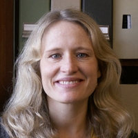 A smiling female professor with shoulder length blonde hair