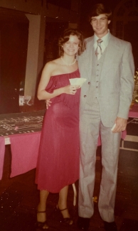 A woman (left, red dress) and a man (grey 3-piece suit) in 1978