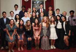 A group of diverse university students in semi-formal attire pose for a multi-row group portrait during a 2026 Student Government Association meeting.