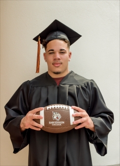 Zavier Pollard ’29 in cap and gown holding a football