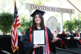 Nina Worley holds an award at commencement