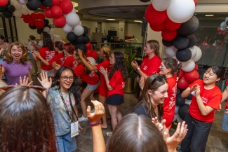 An overhead shot of students and the balloon tunnel, smiling and greeting each other in a hallway