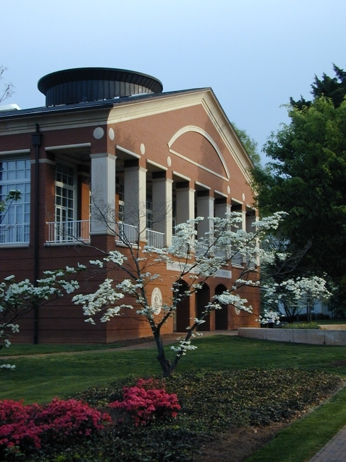 Belk Visual Arts Center exterior, framed by a dogwood tree and pink flowers