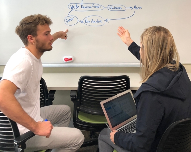 Student Write in German on White Board