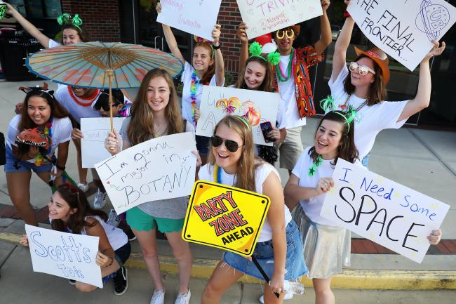 Students hold up funny signs with props