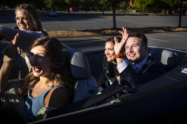 Caroline and Tyler waving with Hollins Worsley '18 driving 