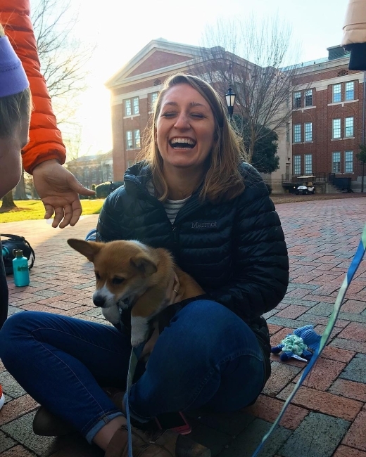 woman laughing with dog in her lap