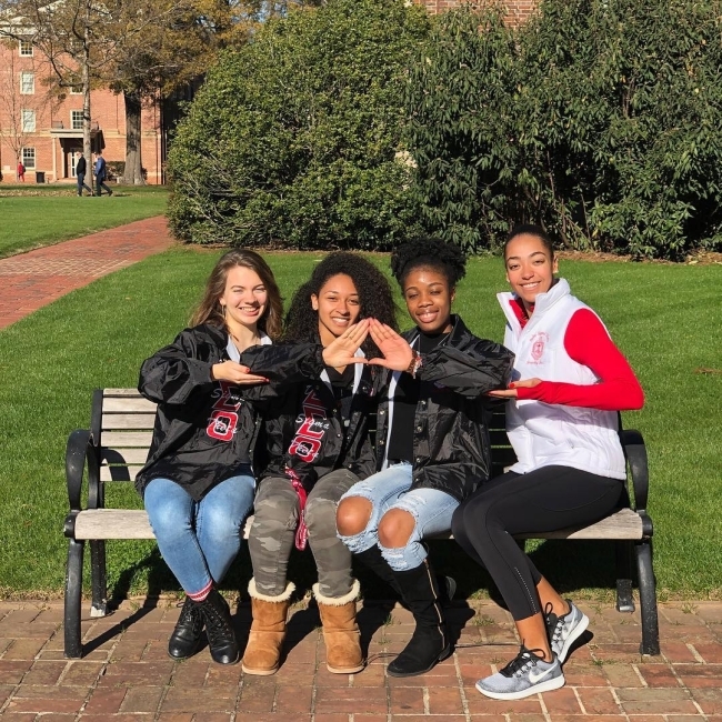 group of Upsilon Mu members sitting on a bench