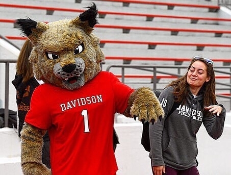 student and mascot posing together