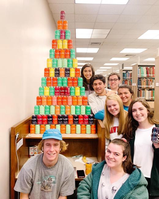 students stand proud next to their bubly can tower