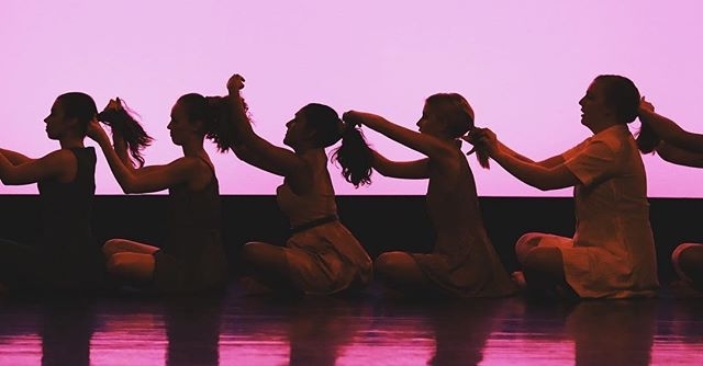 ladies doing each other's hair in a line