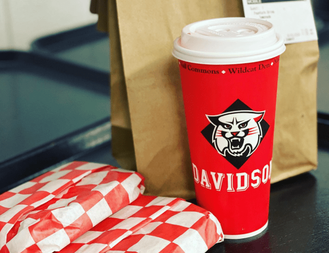 Cup with Davidson Wildcat and "Wildcat Den" and wrapped sandwich and bag