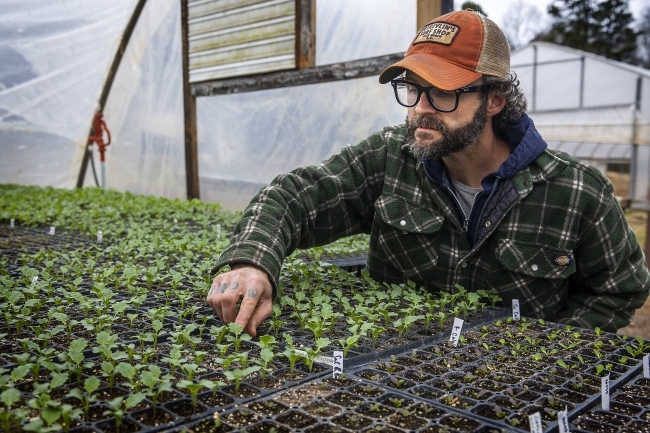 Joe Rowland at the Davidson College Farm Checking on Seedlings