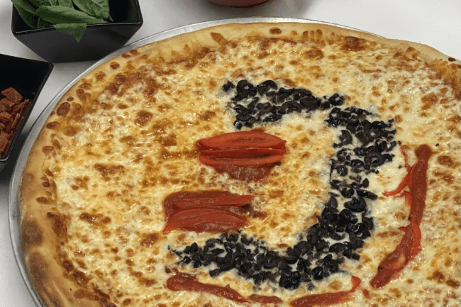 Davidson D on Pizza made of peppers and olives