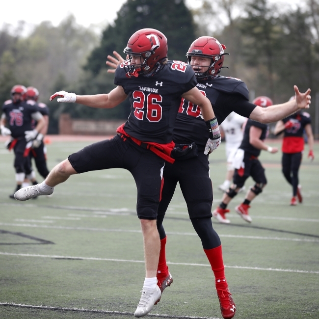 Two Davidson football players jump in celebration