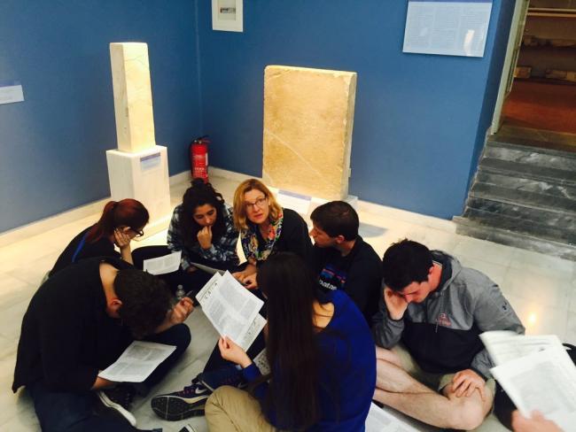 Jeanne Neumann reading inscriptions with students at a museum