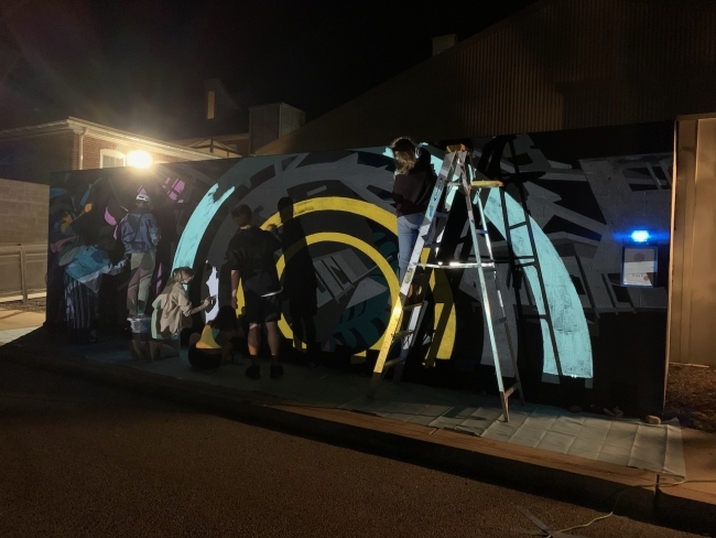 Prof. Joelle Dietrick working on mural project at night