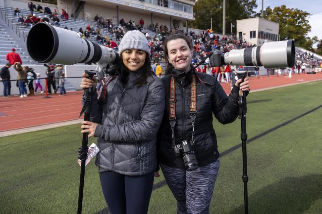 Student Photographers with Large Equipment in Sidelines