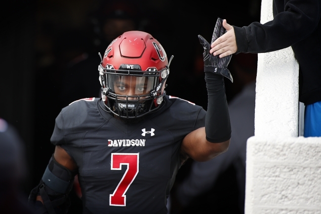 Focused Football Player High Fives Fan when Running Onto the Field