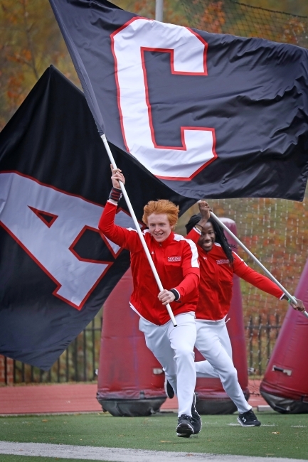 Two Cheerleaders Run with Flags, One with the Letter "A" and the other "C"