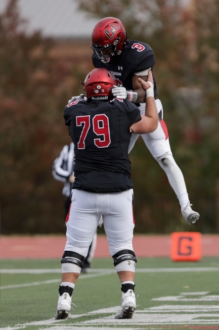 Football Player Picks Up Teammate