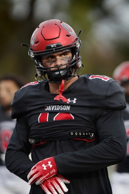 Football Player Looks Focused in Helmet and Face Paint