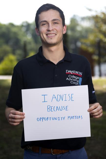 Adviser holds sign reading "I advise because opportunity matters."