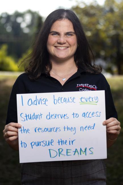 Adviser holds sign saying "I advise because every student deserves to access the resources they need to pursue their dreams."