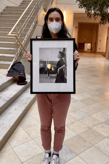 student holds framed artwork