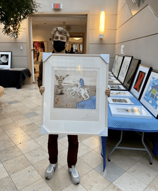 student holds Dali artwork