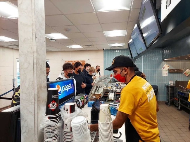 cashier checks out students in line getting food at Qdoba
