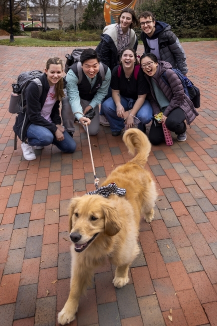 students huddled together with a puppy on a leash