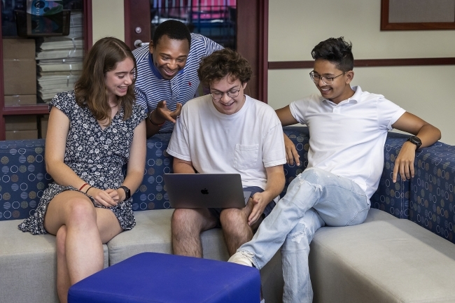 Group of students around laptop