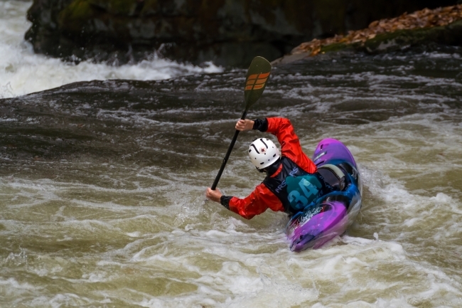 kayaker in rapids at tilt about to go over waterfall