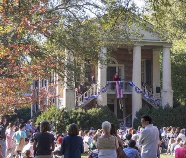 old columned building with people sitting on lawn in front