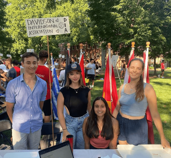 four students at table with sign that says "davidson international association"