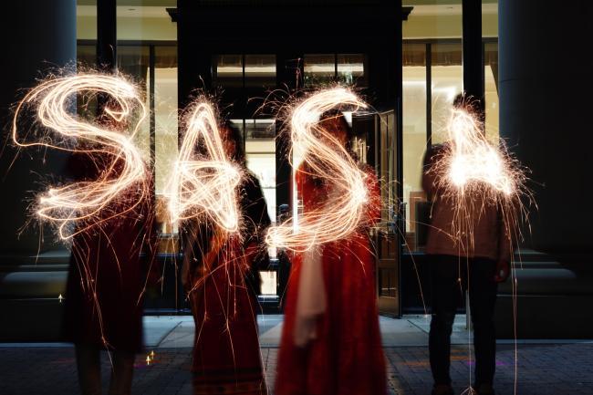 students with sparklers that spell out "SASA"