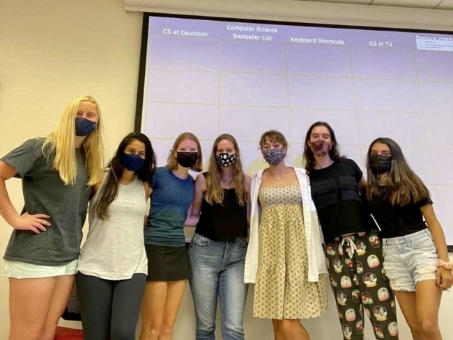 women standing in front of jeopardy board