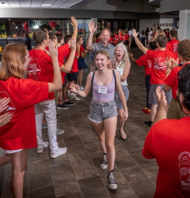 Students cheering on a student with parents in background