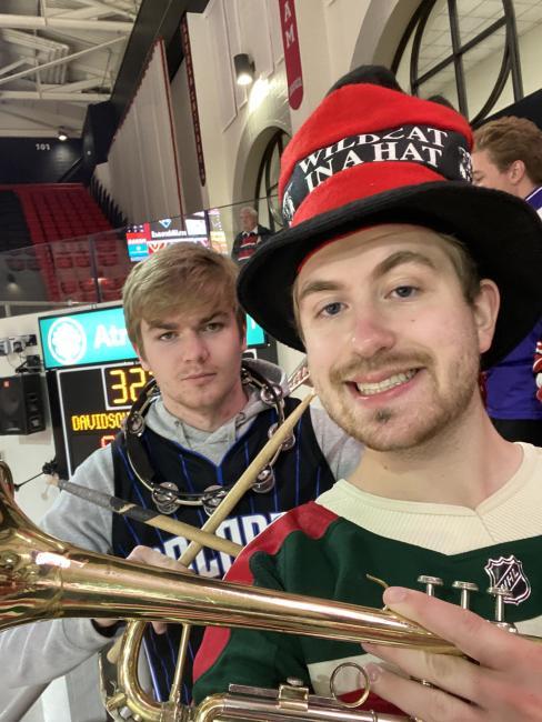 Students in pep band smiling with instruments