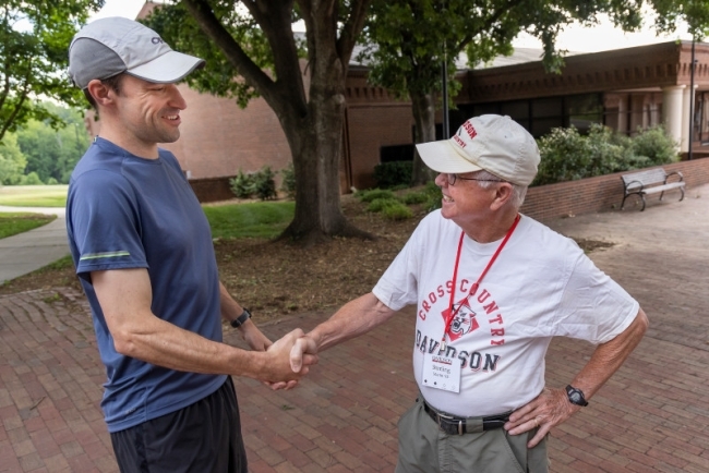 men shaking hands and smiling at each other